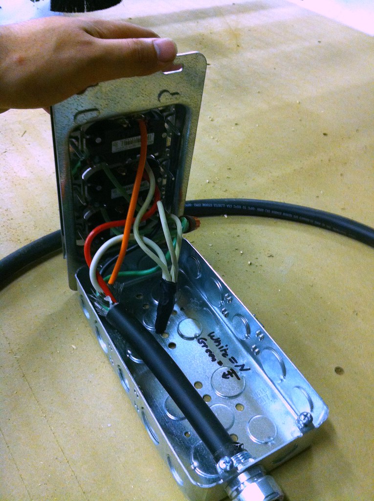 Professional electrician performing wiring work on electrical breakout panel